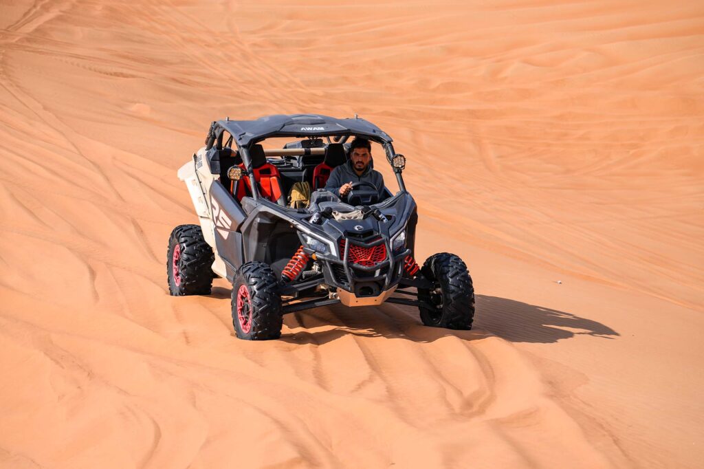 Dune Buggy driver navigating Dubai red sand dunes