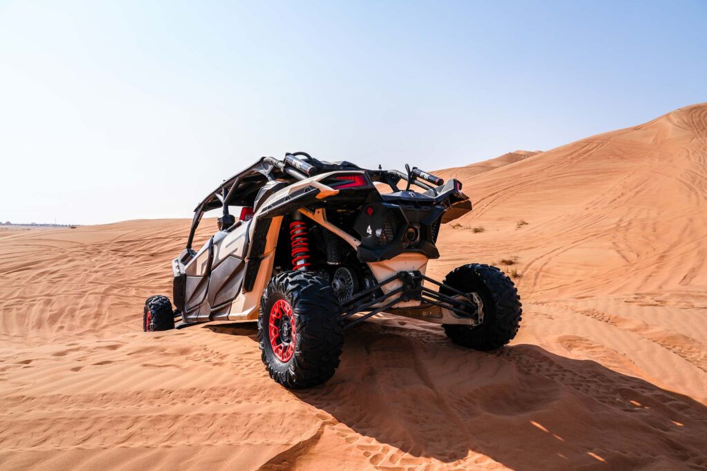Can-Am buggy climbing high sand dune in Dubai desert